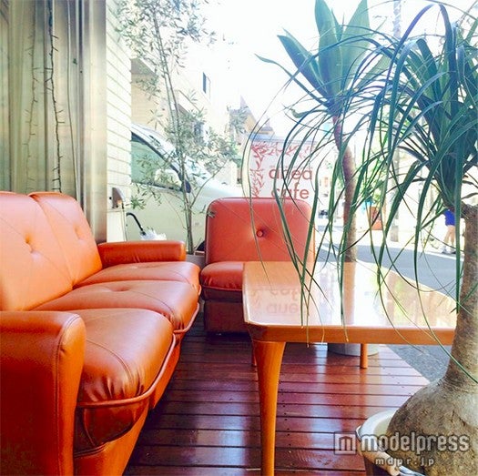 オレンジのソファがお洒落なテラス席／画像提供：anea cafe
