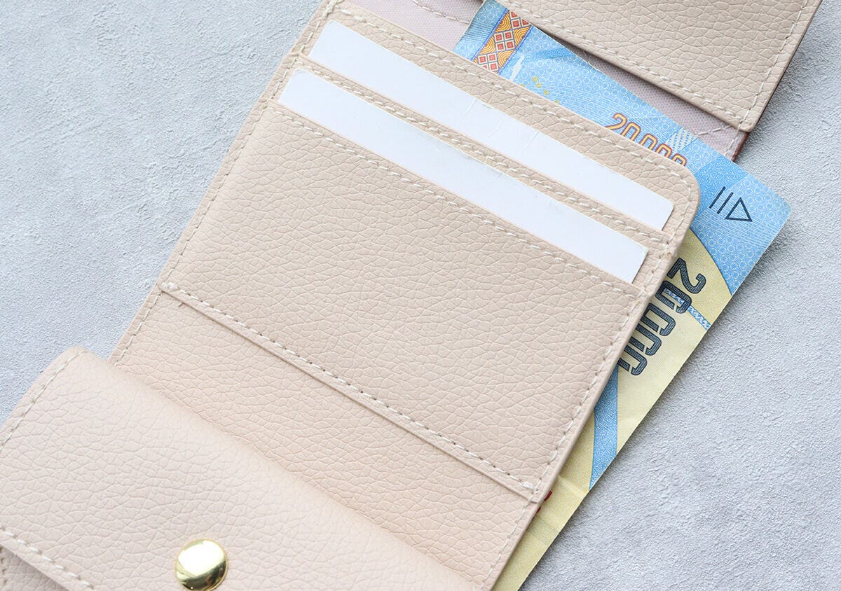 ミニ財布の札入れ部分に1万円札とカードが収納されている様子 ミニ財布の札入れ部分に1万円札とカードが収納されている様子