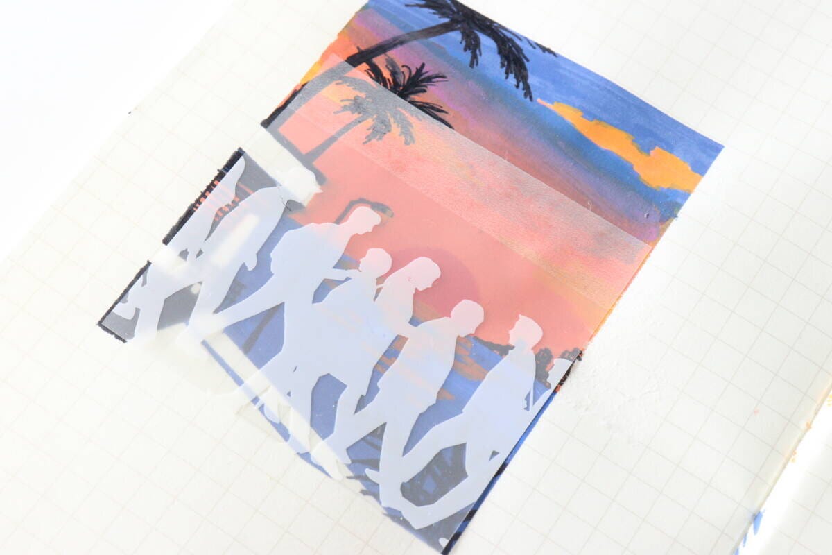 人々デザインのふせんが手書きの夕焼けとヤシの木のイラストに重ねられている