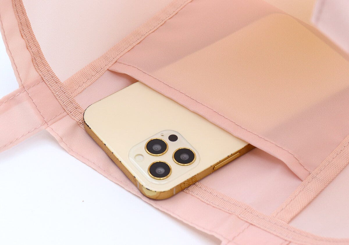 ピンクのトートバッグの内ポケットにスマホを入れている様子