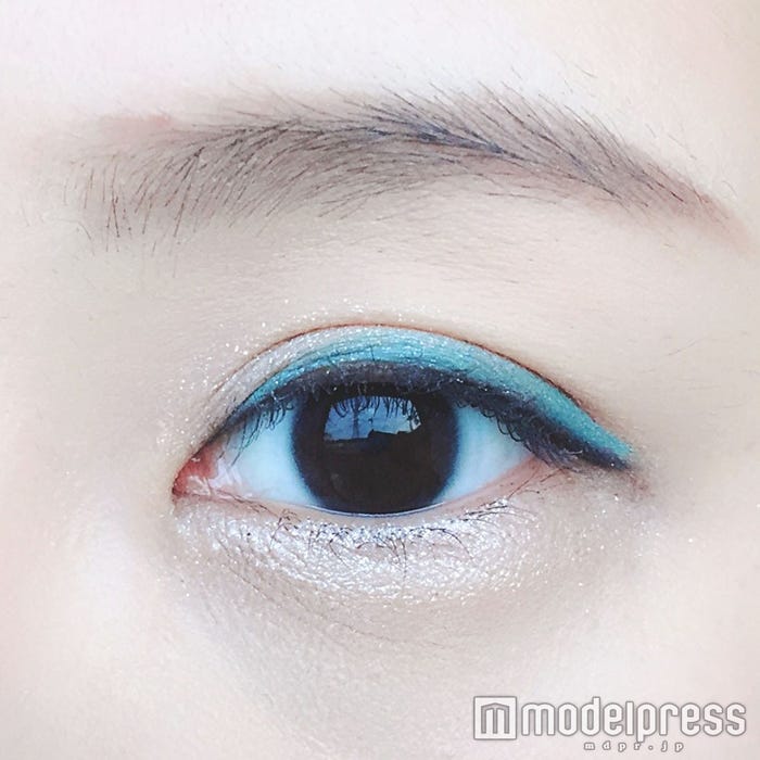ネイビーのアイライナーの上に【キャンドゥ】「TMカラーアイライナー」“アイスブルー”を引く/写真:onoaki(C)モデルプレス