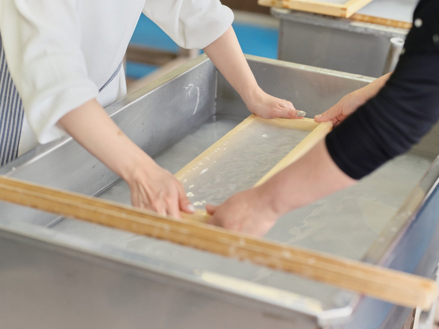均等に原料を広げるのが難しい。サポートして貰いながら丁寧に和紙を作っていきます／提供画像
