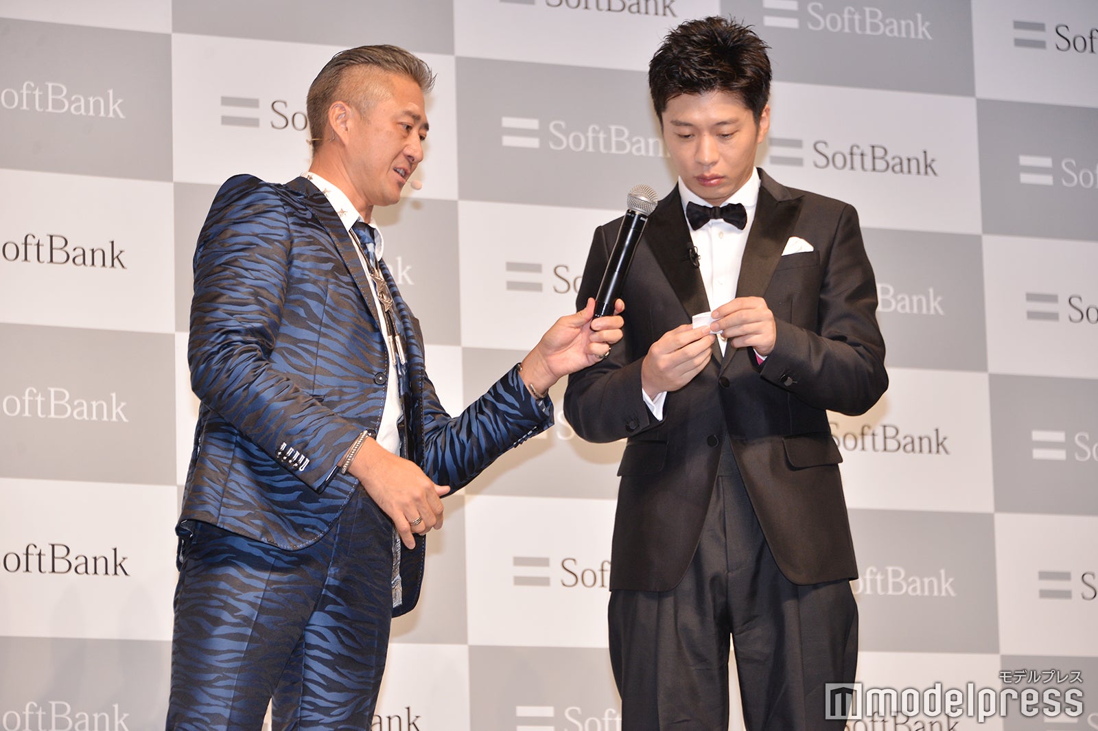 半信半疑で紙を広げる田中圭（C）モデルプレス