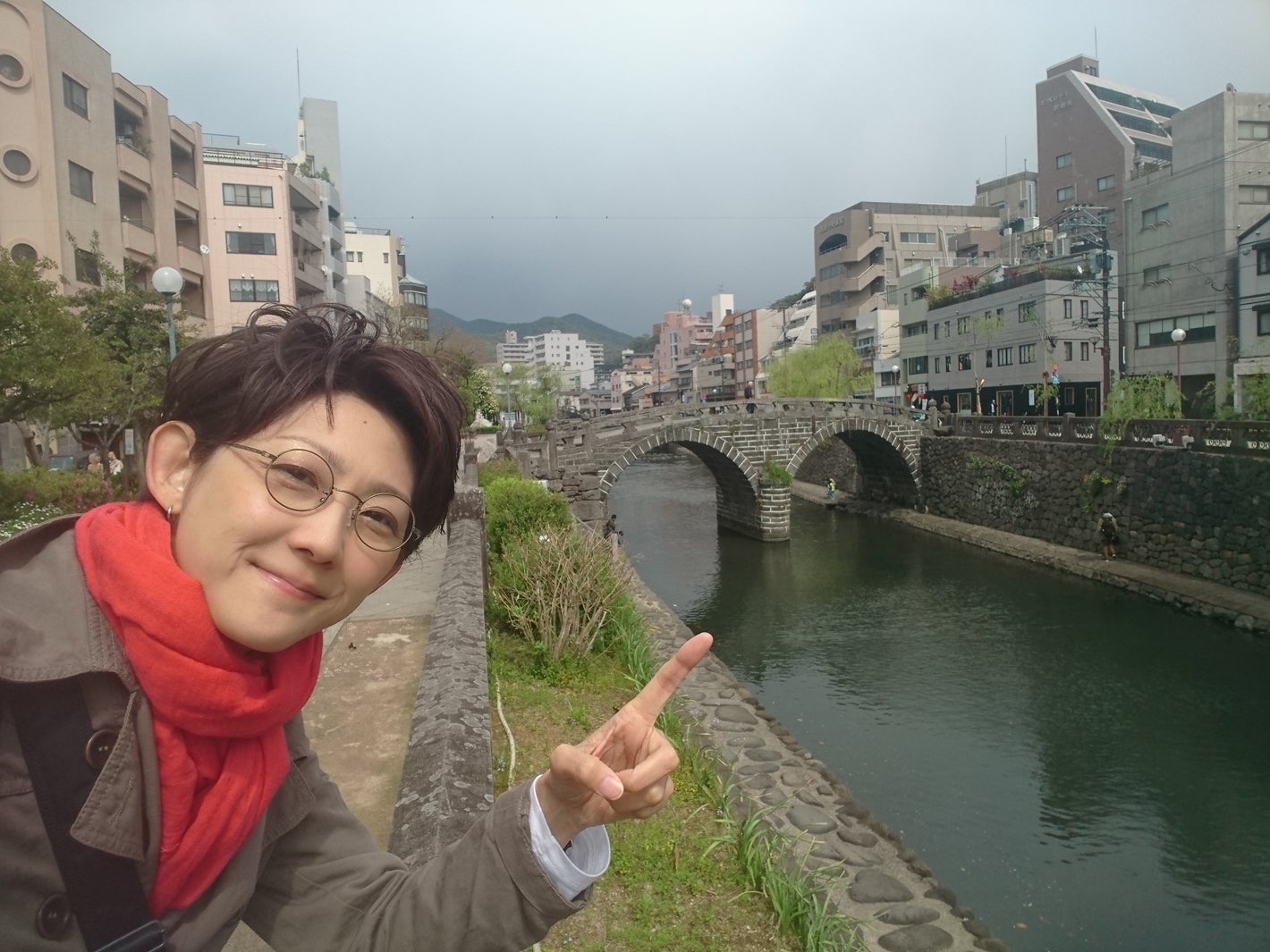 長崎の眼鏡橋の前で丸眼鏡をかけて（提供写真）