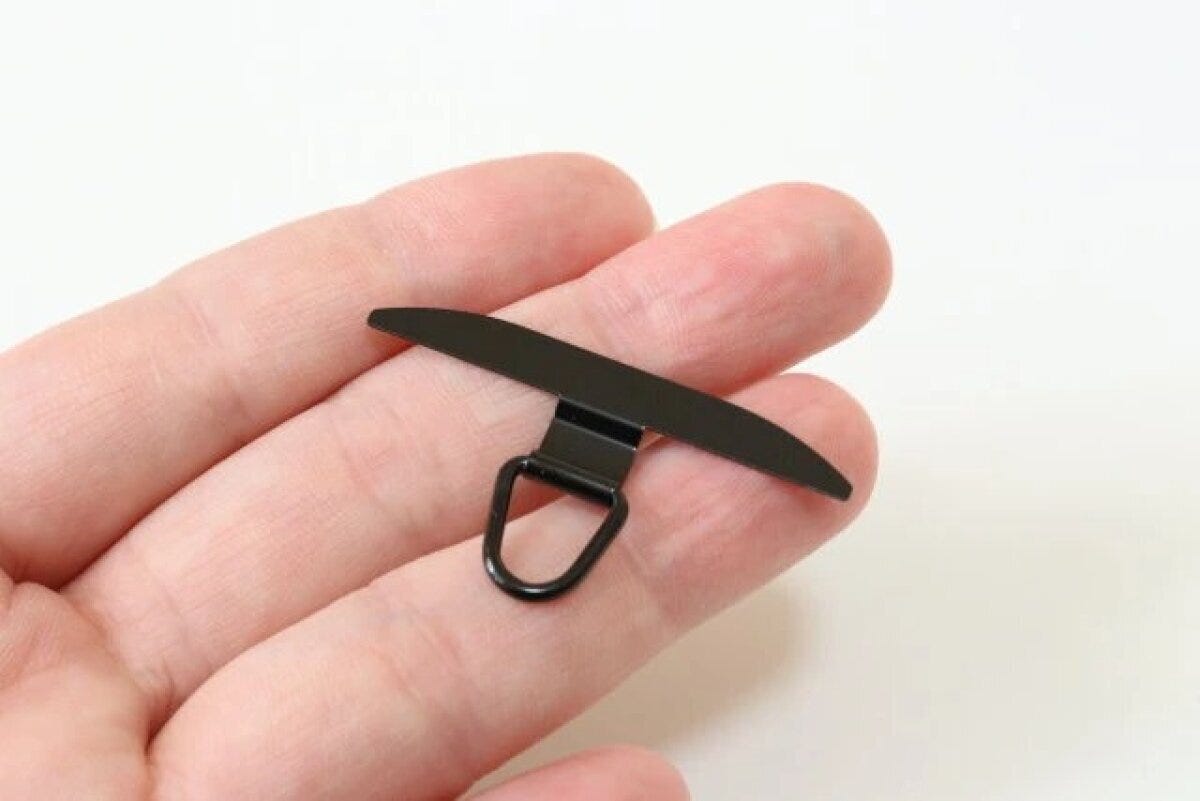 黒いステンレス製スマホストラップホルダーを手のひらに乗せた様子