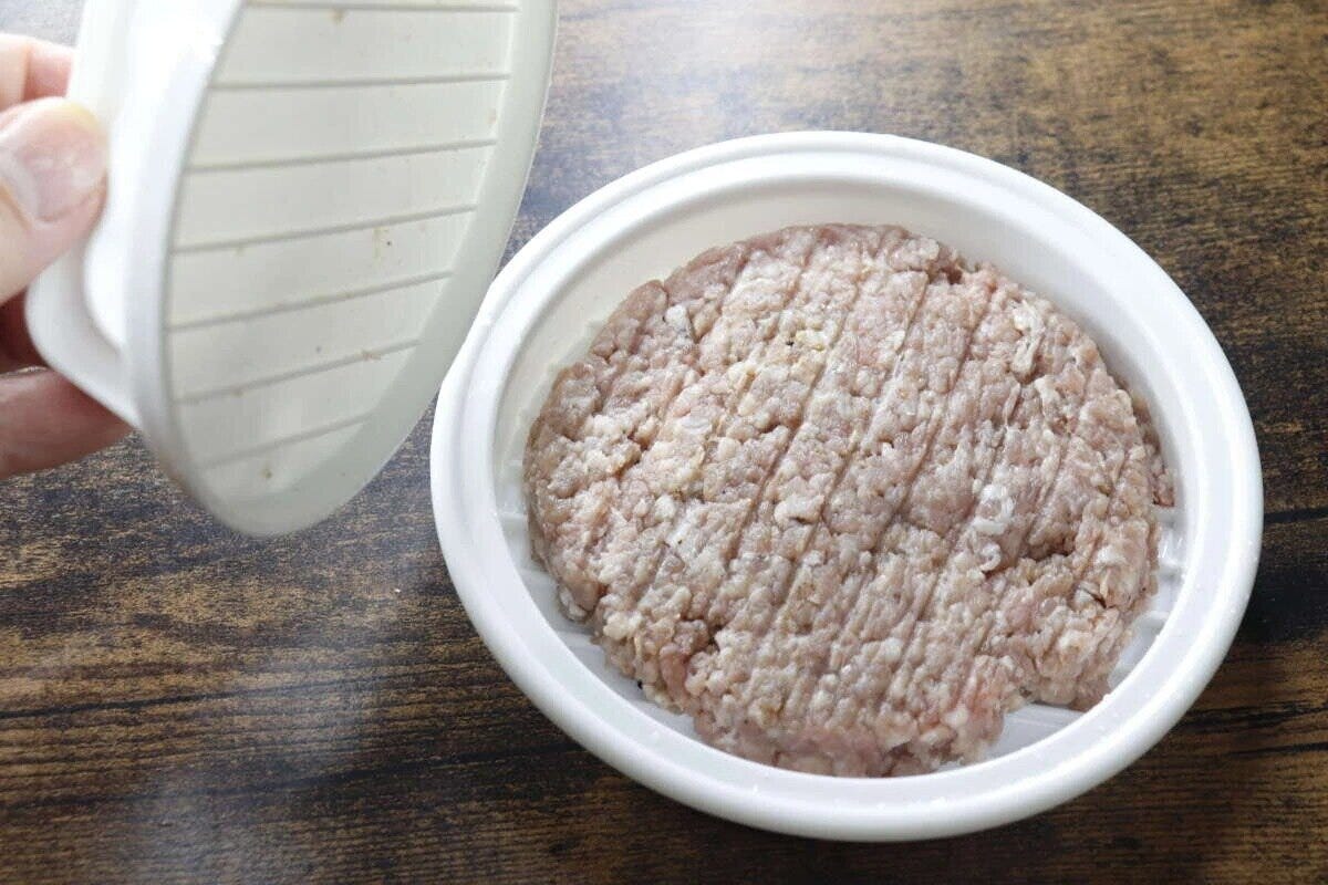 ミートプレスでひき肉を円形に成形している