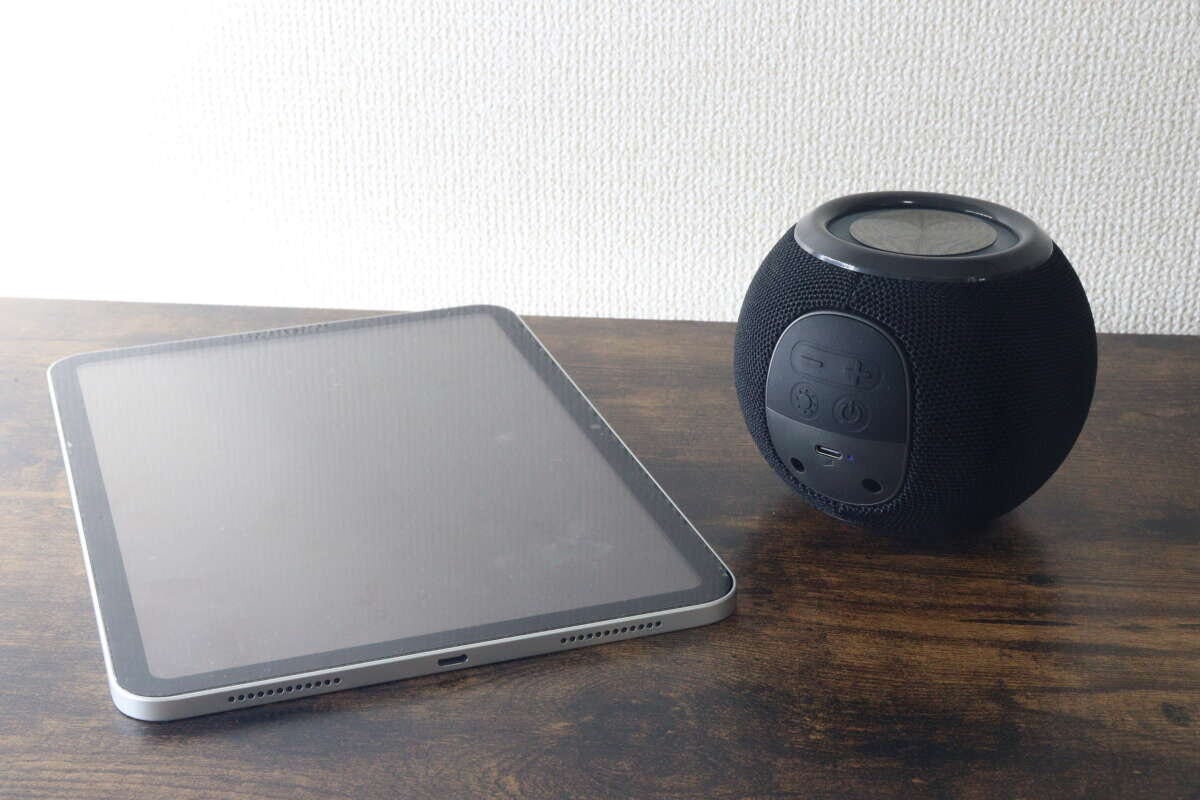 タブレット端末と黒いボール形スピーカーを並べて置いている様子 タブレット端末と黒いボール形スピーカーを並べて置いている様子