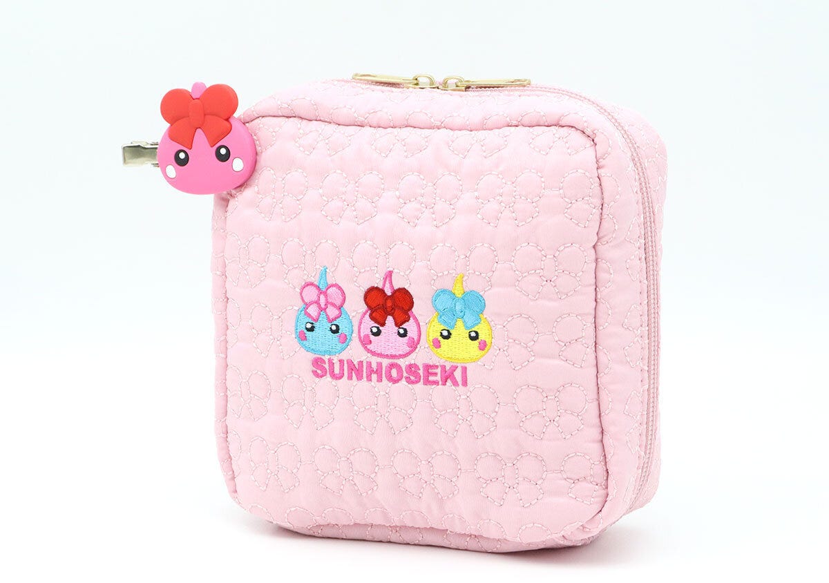 ほっぺちゃん刺繍入りのピンクのキルティングポーチに前髪クリップを付けた様子