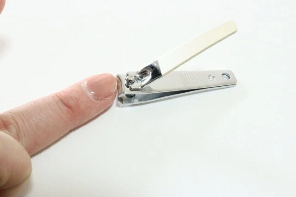人差し指の爪を爪切りで切っている手元のクローズアップ 人差し指の爪を爪切りで切っている手元のクローズアップ