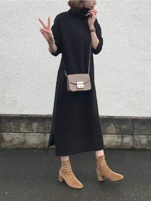 黒のニットワンピースにベージュのコーデュロイブーツを合わせたコーデ