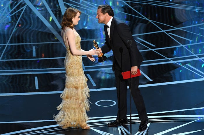 昨年、主演男優賞を受賞したレオナルド・ディカプリオからトロフィーを受け取るエマ・ストーン /photo:Getty Image