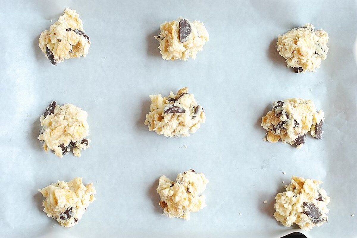 オーブンシートを敷いた天板にクッキー生地を間隔をあけて並べた焼成前の状態