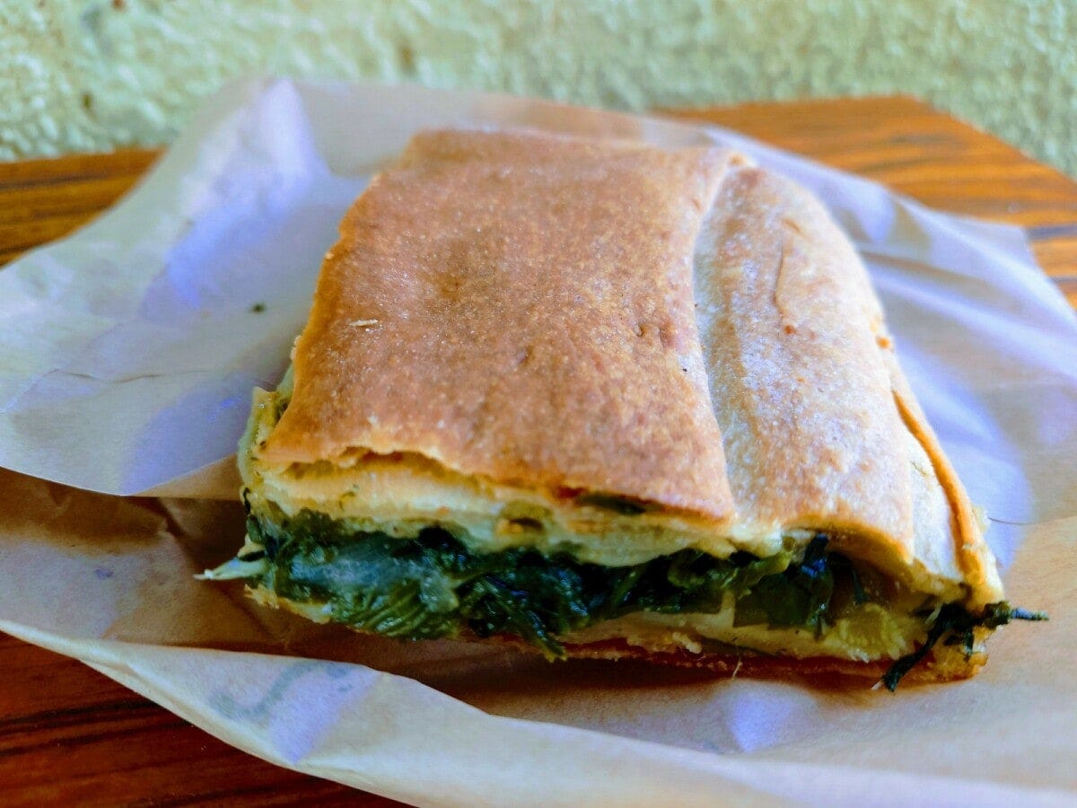 ほうれん草、玉ねぎ、ディルなどのフィリングがたっぷり入った「スパナコピタ」（ほうれん草のパイ）