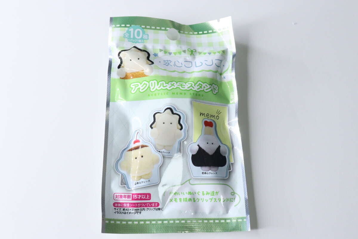 求心フレンズのアクリルメモスタンドのパッケージ。緑のチェック柄にプリンや牡蠣のキャラクター。