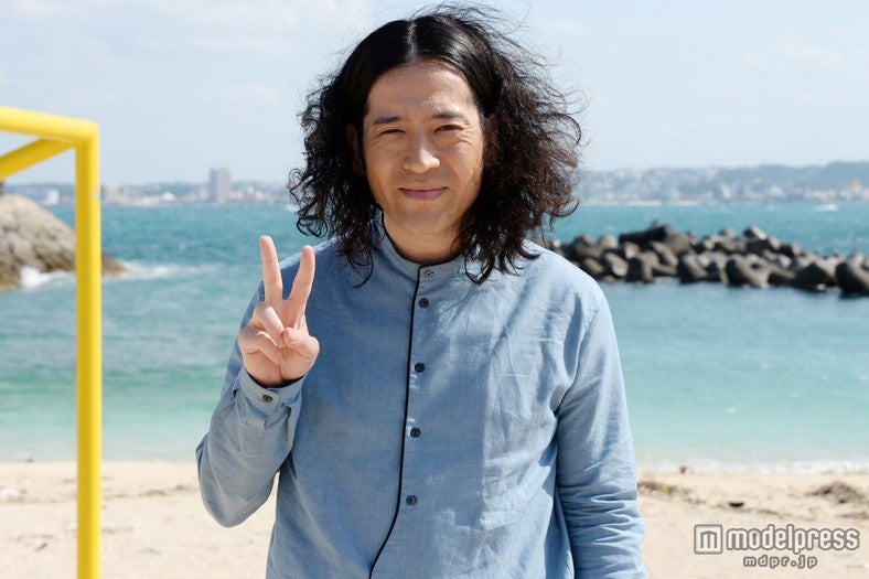 沖縄の青空と海をバックにして