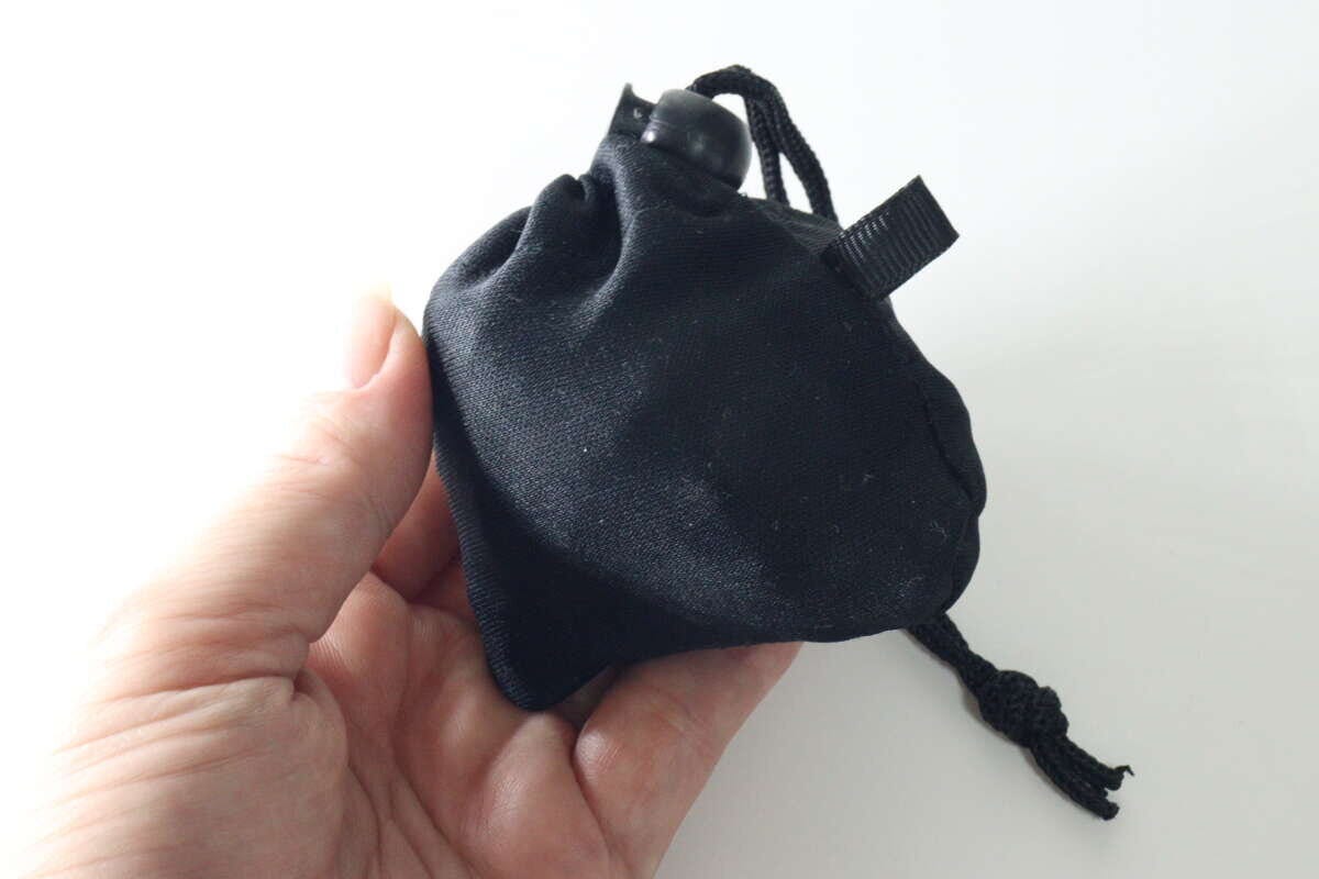 女性の手のひらに乗せられた黒い巾着型エコバッグ