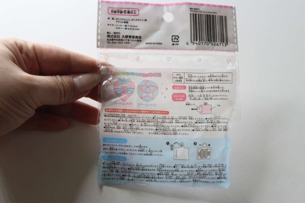 女性の手が持っているマジカルフラッシュコンパクトのパッケージ裏面。注意書きや説明が記載されている 女性の手が持っているマジカルフラッシュコンパクトのパッケージ裏面。注意書きや説明が記載されている
