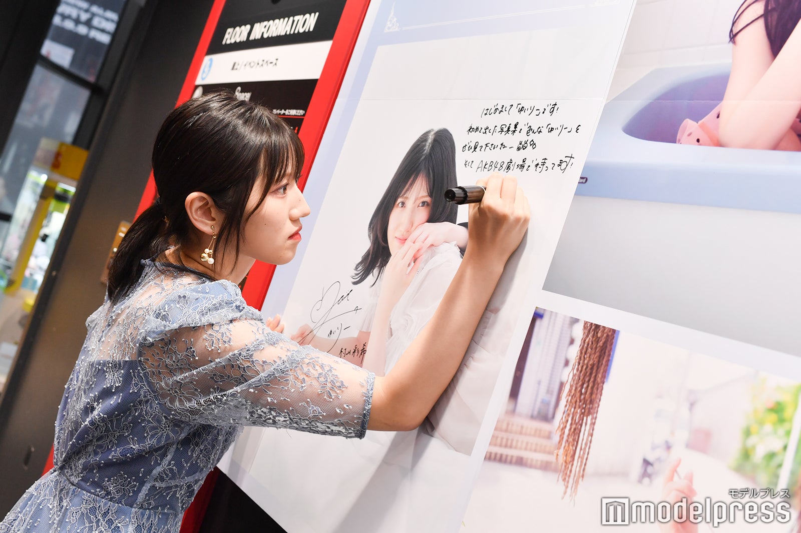 パネルに直筆サインを入れる村山彩希（C）モデルプレス