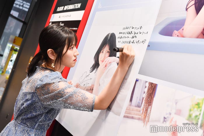 パネルに直筆サインを入れる村山彩希(C)モデルプレス