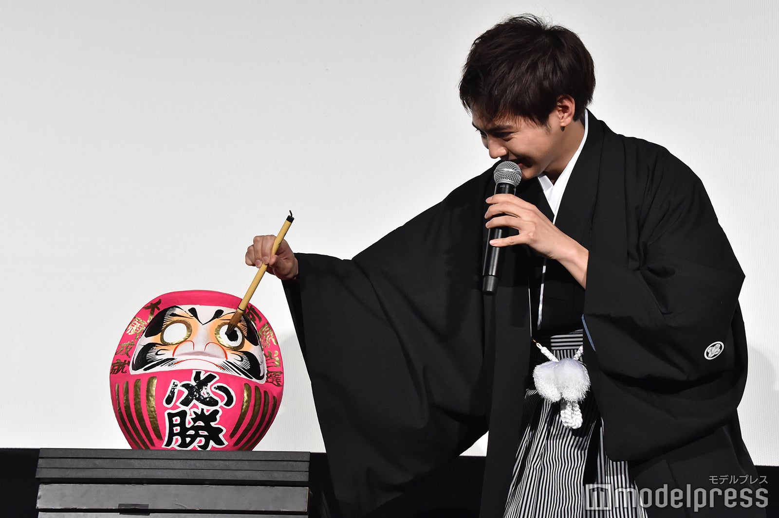 慎重にだるまの目入れをする片寄涼太 （C）モデルプレス