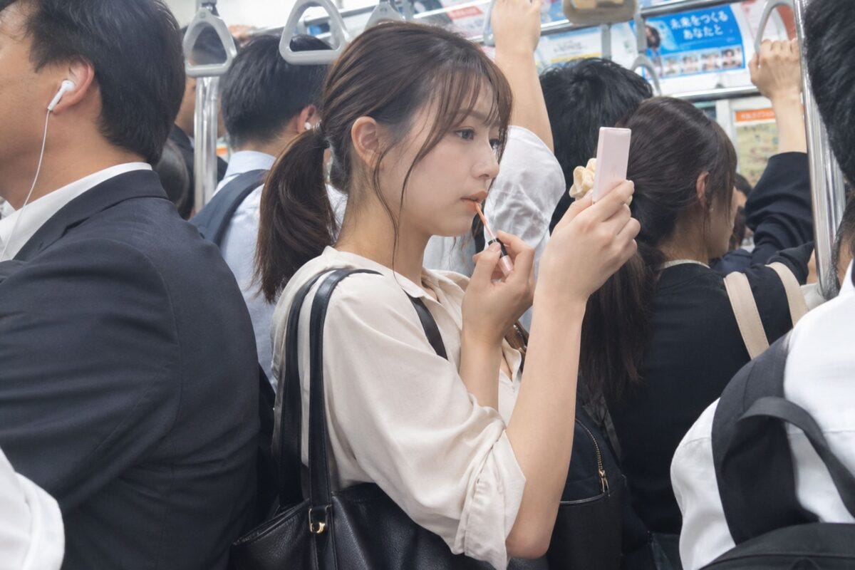 満員電車で化粧をする女性