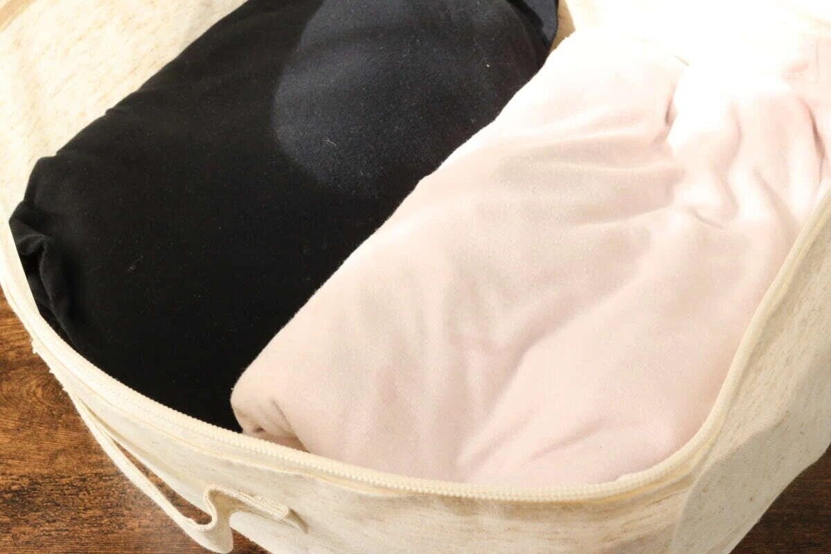麻入り収納ボックスの中に黒とピンクの衣類が収納されている様子