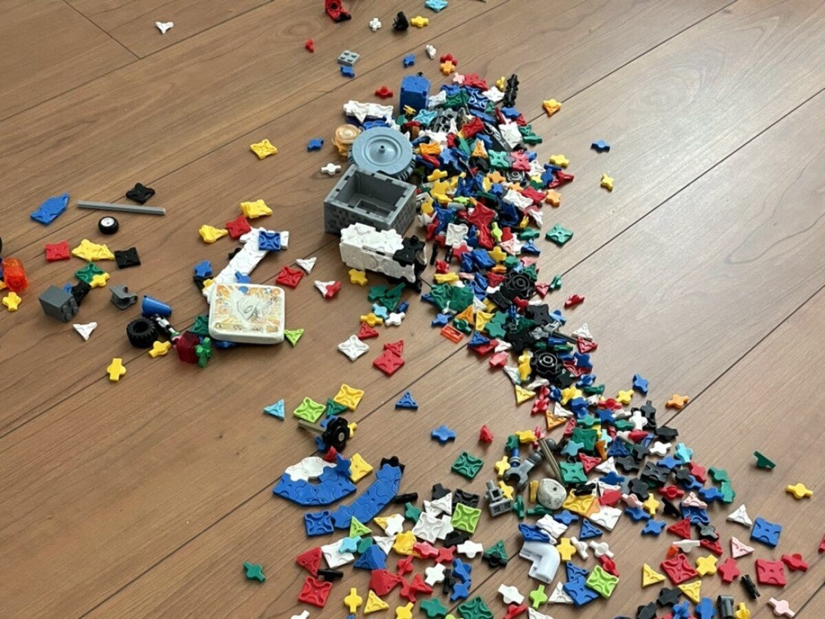 床一面に散らばったブロックのおもちゃ 木目のフローリングの床一面に散らばったカラフルな組み立てブロックのおもちゃ
