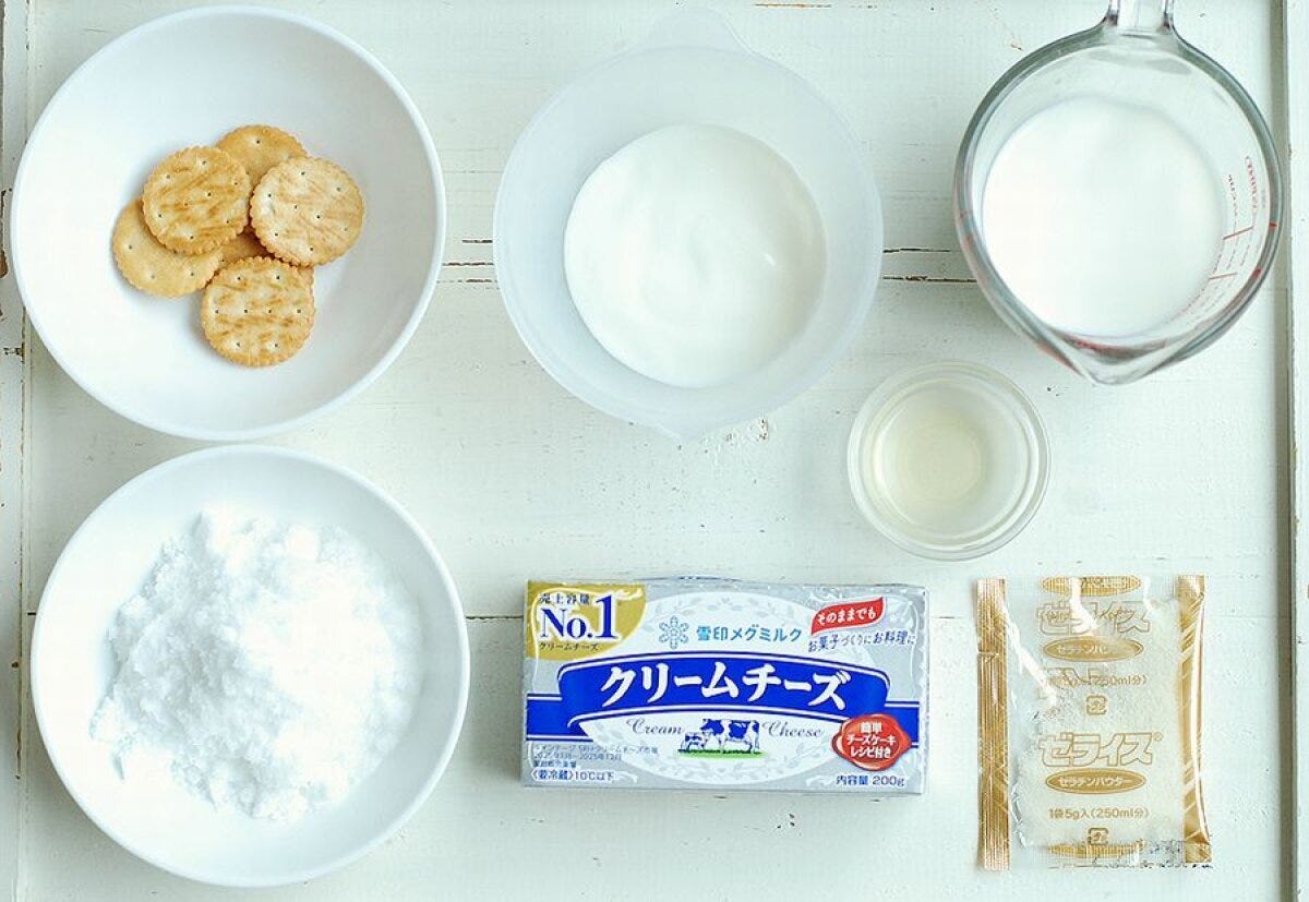 レアチーズケーキの材料が白い木目のテーブルに並べられている俯瞰写真 レアチーズケーキの材料が白い木目のテーブルに並べられている俯瞰写真