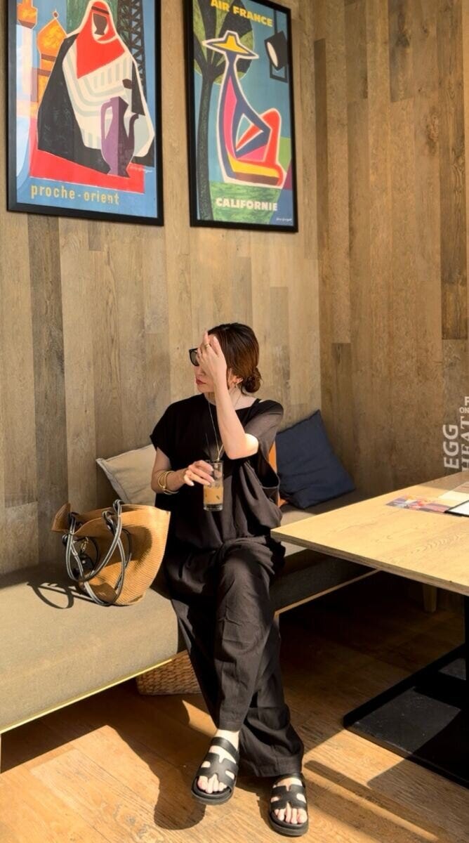カフェのベンチでアイスコーヒーを飲む黒い服の女性 カフェのベンチでアイスコーヒーを飲む黒い服の女性