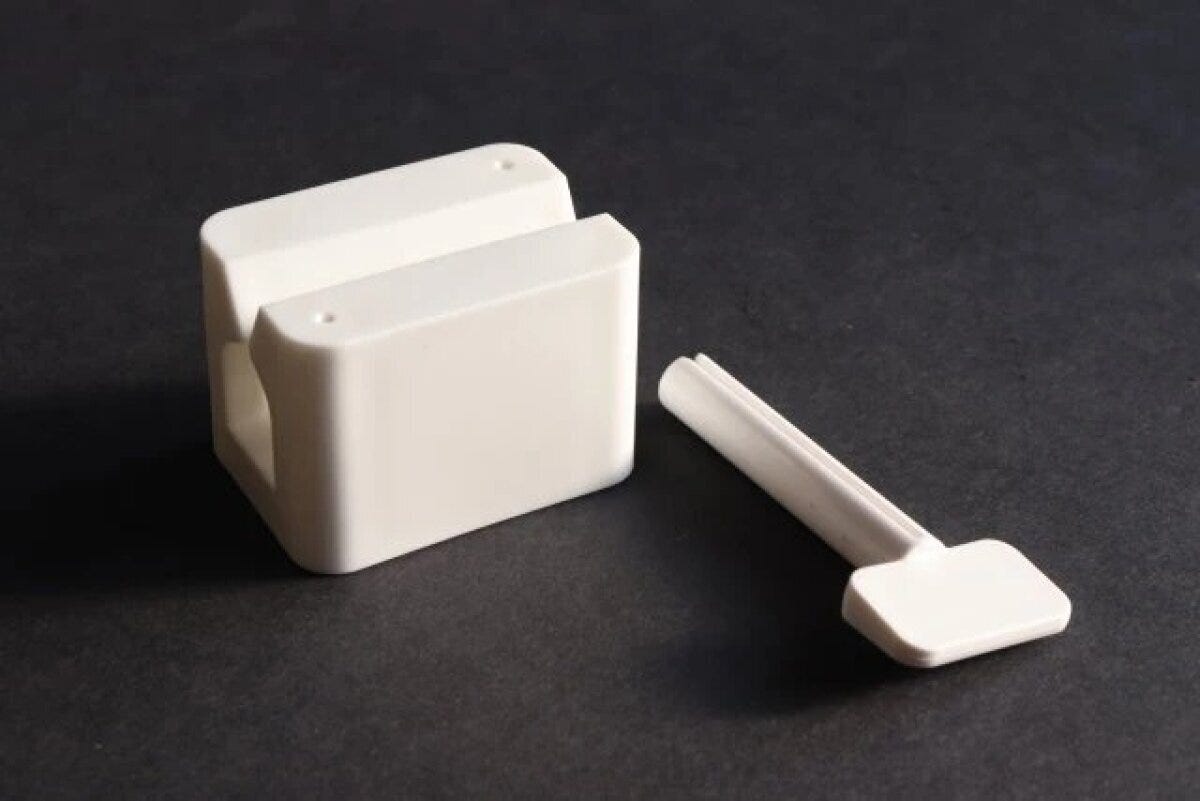 白いチューブ絞り器の本体と棒状のパーツが並べられている