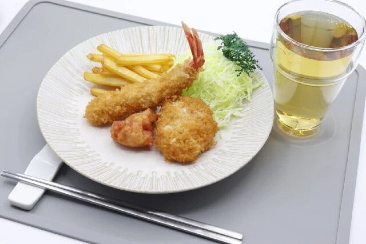 とんかつ皿に揚げ物とフライドポテト、キャベツが盛り付けられた食卓 とんかつ皿に揚げ物とフライドポテト、キャベツが盛り付けられた食卓