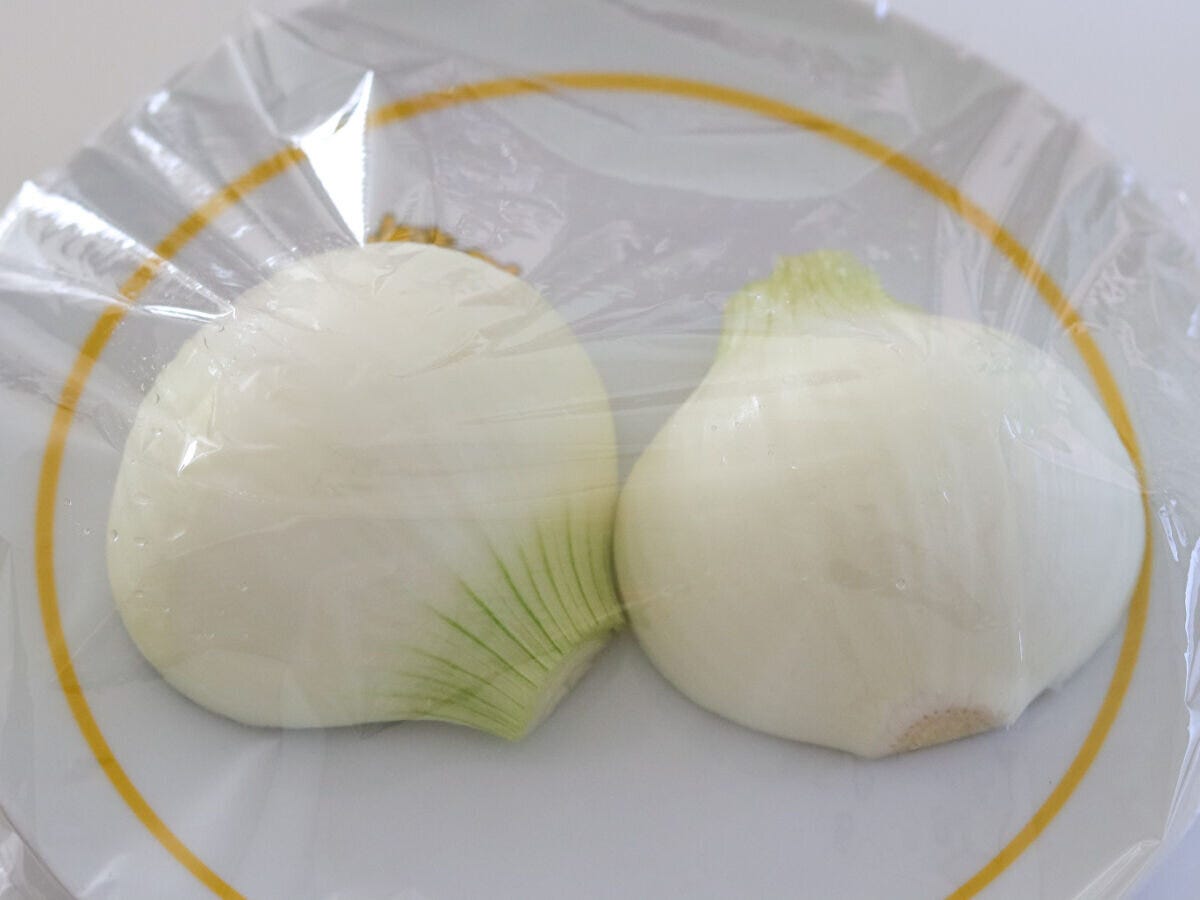 耐熱皿にラップをかけた半割りの新玉ねぎ 耐熱皿にラップをかけた半割りの新玉ねぎ