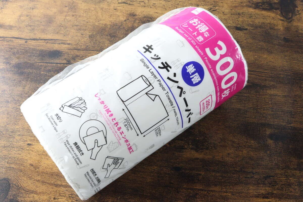 木目調のテーブルに置かれたダイソー単層キッチンペーパーのパッケージ 木目調のテーブルに置かれたダイソー単層キッチンペーパーのパッケージ