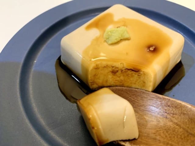 わさび醤油をのせたゴマ豆腐をスプーンですくった様子