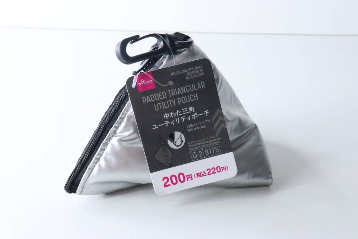 白い背景に置かれたシルバーの三角ポーチと商品タグ