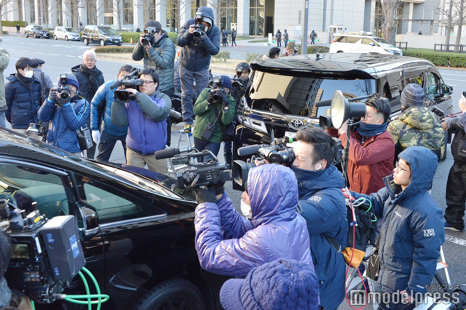 裁判所を後にする車両を大勢の報道陣が取り囲んだ（C）モデルプレス