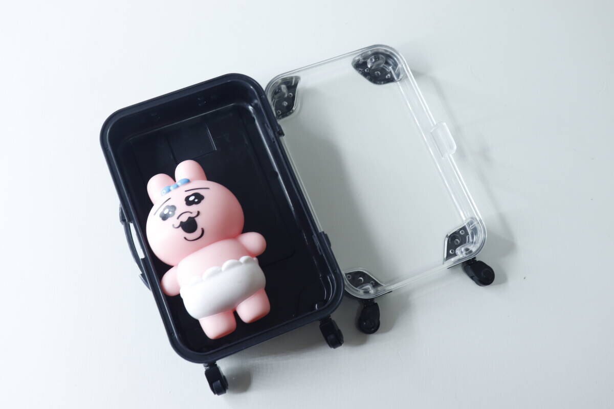 観音開きになったミニキャリーケースとピンクのぬいぐるみ
