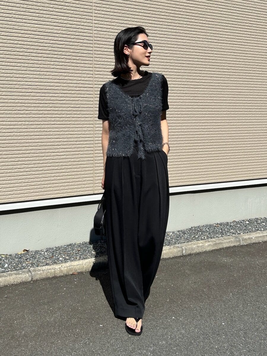 黒Tシャツとワイドスラックスにフェザーニットベストを着用した女性 黒Tシャツとワイドスラックスにフェザーニットベストを着用した女性