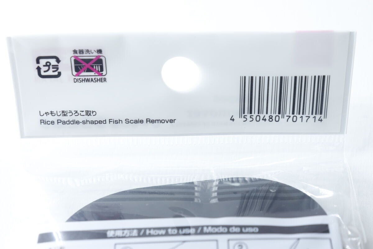 しゃもじ型うろこ取りのパッケージ上部、食洗機不可の表示とJANコードが写っている