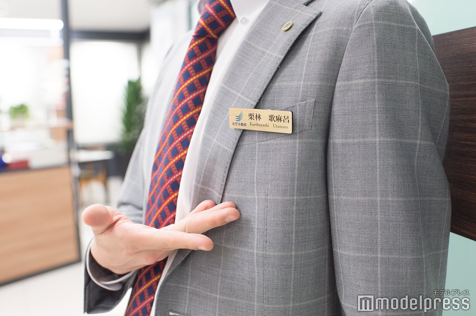 胸元で輝く金色のバッジ