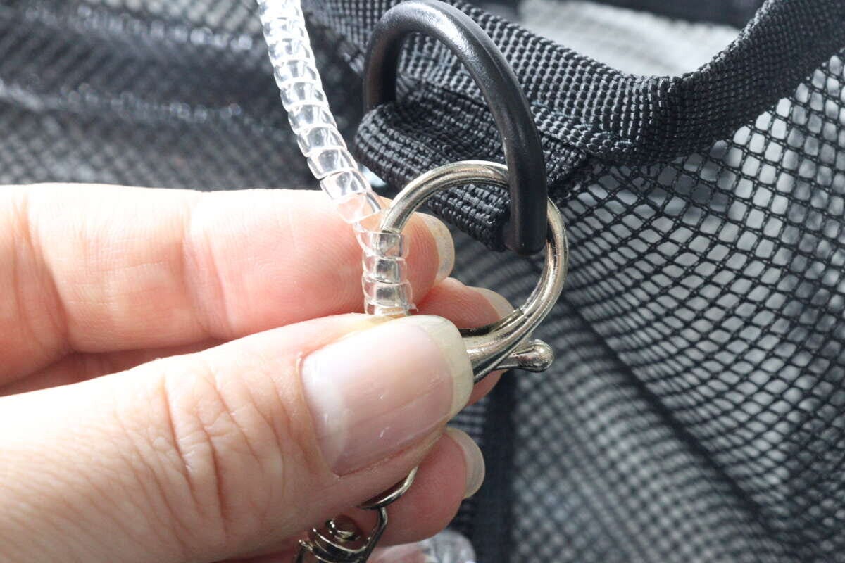 キーホルダーの金具に透明なコイルを巻き付けている手元のアップ