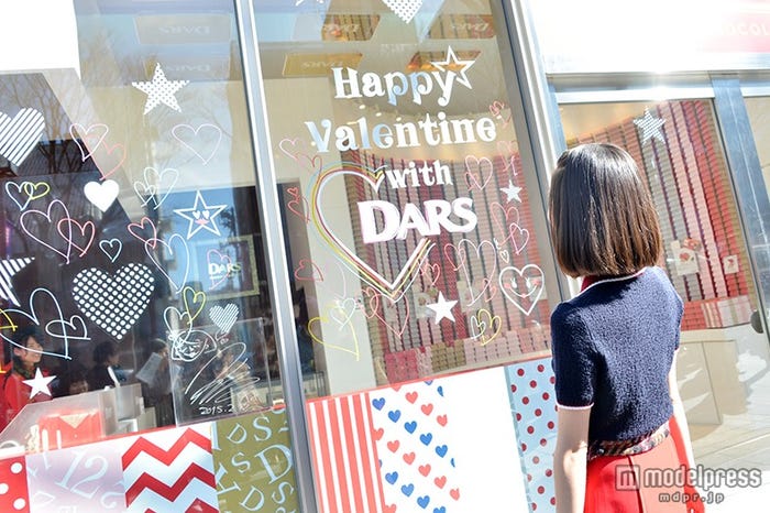 自身がペインティングしたガラス窓を眺めている水原希子