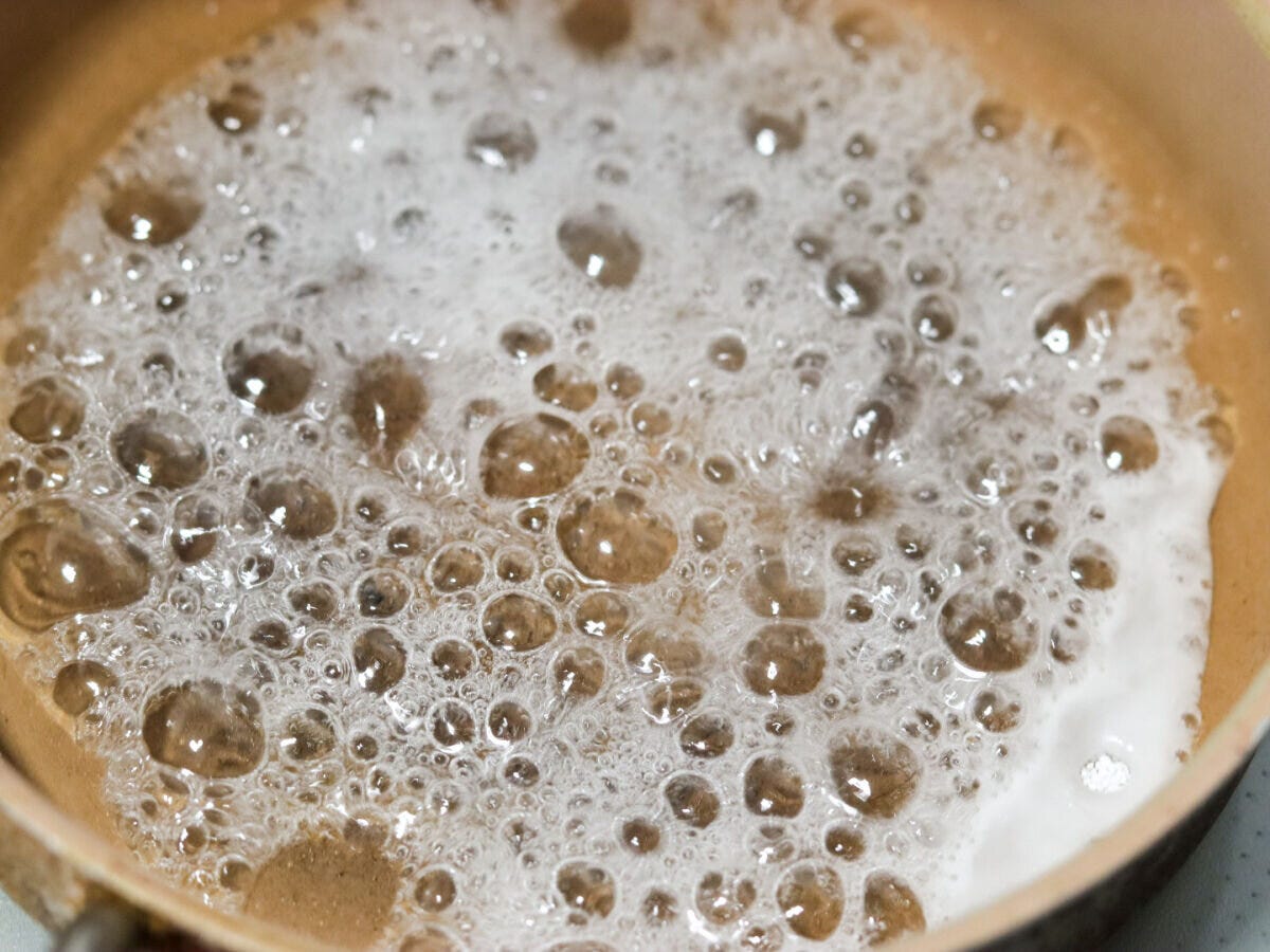 小鍋で砂糖と水を加熱し大きな泡が立っているカラメル作りの様子