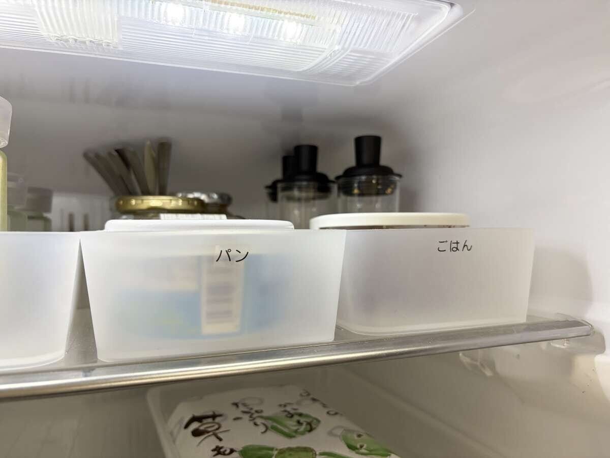 冷蔵庫の中に「パン」「ごはん」とラベルを貼った半透明の収納ケースが並ぶ様子