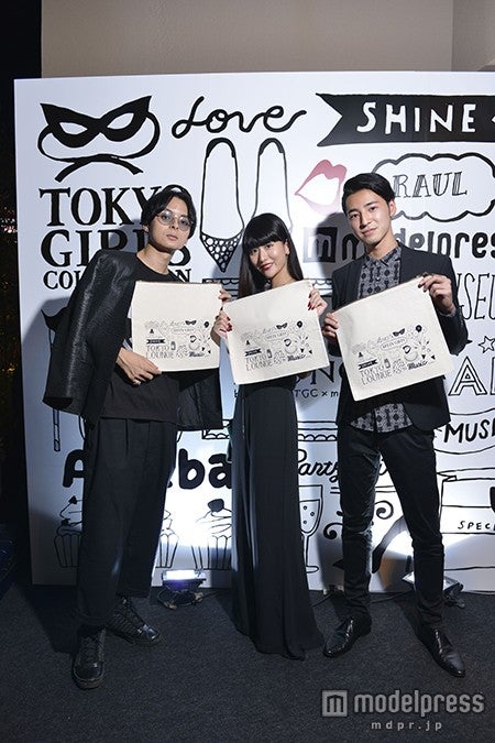 エントランスパネルの前で／来場者にプレゼントされたクラッチバッグ