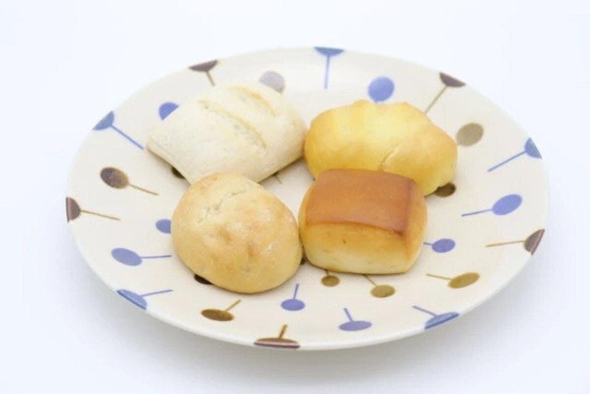 ポップな模様の大皿にミニパンが4つ盛り付けられている ポップな模様の大皿にミニパンが4つ盛り付けられている