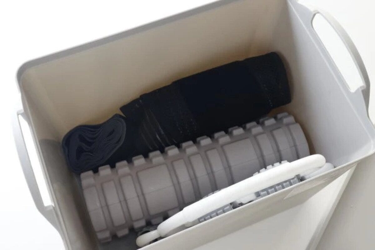 グレーの蓋付スクエア収納ボックスの中にエクササイズ用品が収納されている