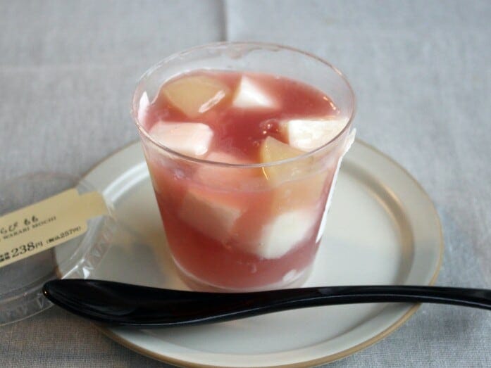 ピンク色の桃のジュレに、ミルクゼリーや桃のシロップ煮がゴロゴロ