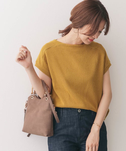 マスタードイエローのトップスを着た女性