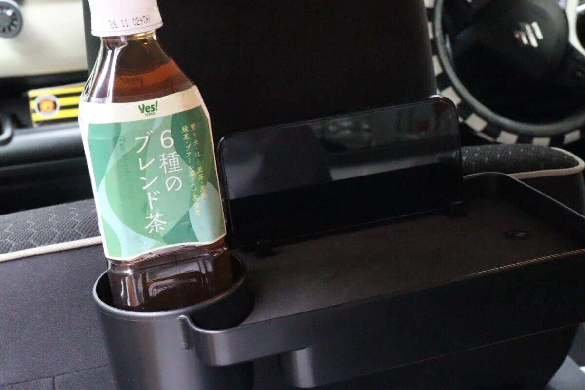 車用トレイにペットボトルのお茶とスマートフォンが置かれている 車用トレイにペットボトルのお茶とスマートフォンが置かれている
